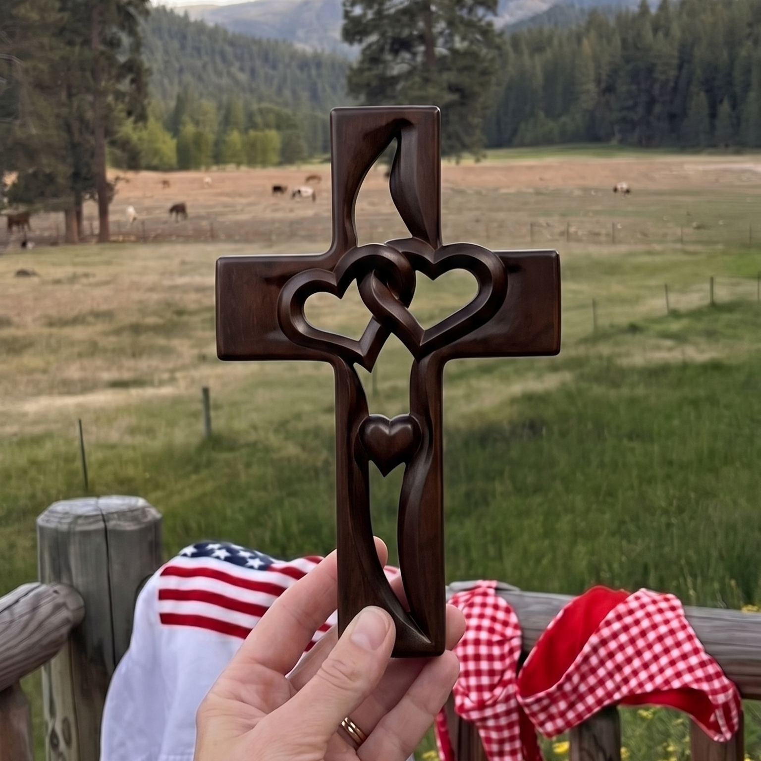 Two Hearts Cross in Dark Walnut finish, hand-carved wooden wall cross held up on a rural fence line